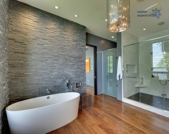 Эффектный интерьер просторной ванной комнаты с отделкой стен камнем