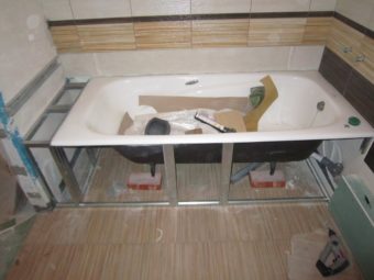 Установка ванны на плитку, но закрытое пространство под ванной не отделано